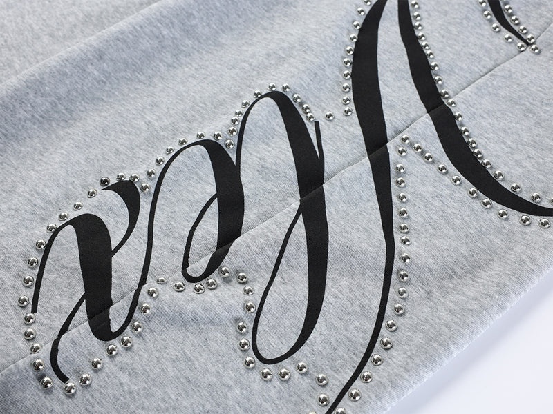 Pantalon de survêtement à jambes larges avec imprimé graffiti cursif orné de rivets