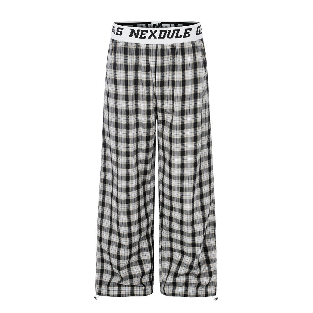 Wide-leg plaid pants with white logo elastic waistband in black and white checkered pattern, front view