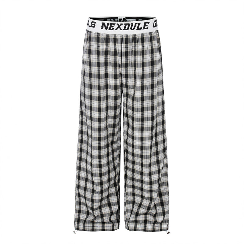 Wide-leg plaid pants with white logo elastic waistband in black and white checkered pattern, front view