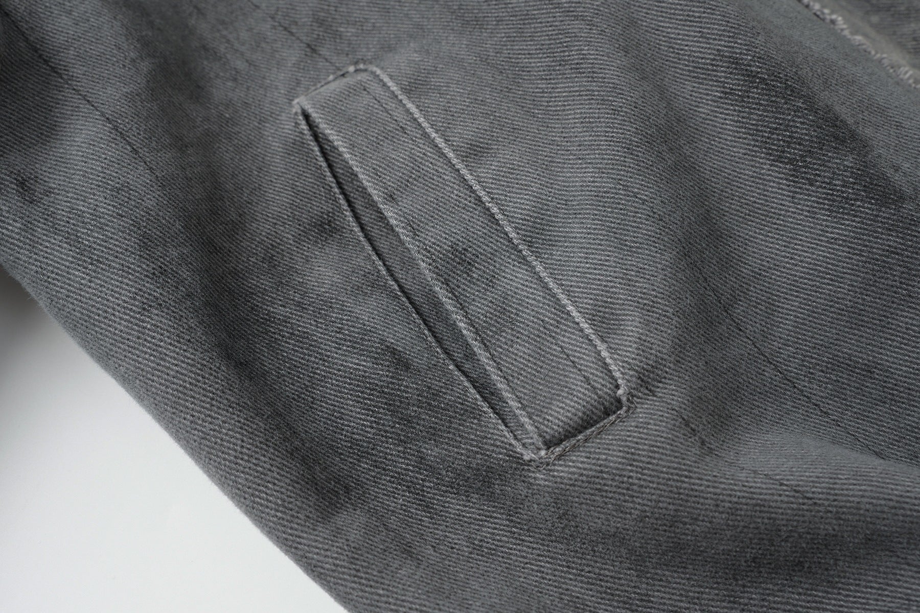 Veste bomber en jean délavé déconstruite à empiècement croisé et coutures effilochées