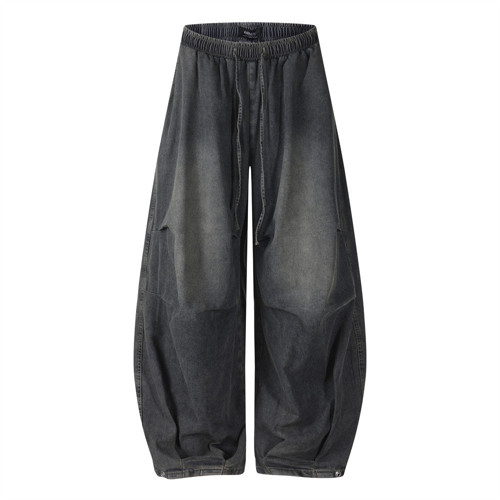 Men's acid-washed wide-leg balloon jeans in dark navy with elastic waistband and gathered ankle cuff, front and back view