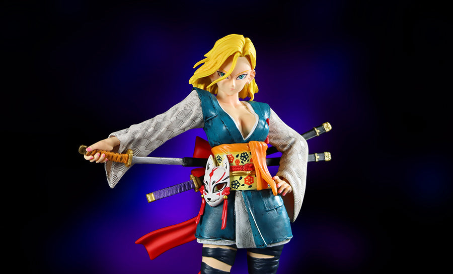 The Seakoff Android 18 Collectible Figure – Dragon Ball Z features a detailed anime-style woman with blonde hair in a samurai pose. Wearing a blue kimono with white sleeves, a colorful belt with an attached mask, and holding a katana, she has two extra swords strapped to her back against a dark background.