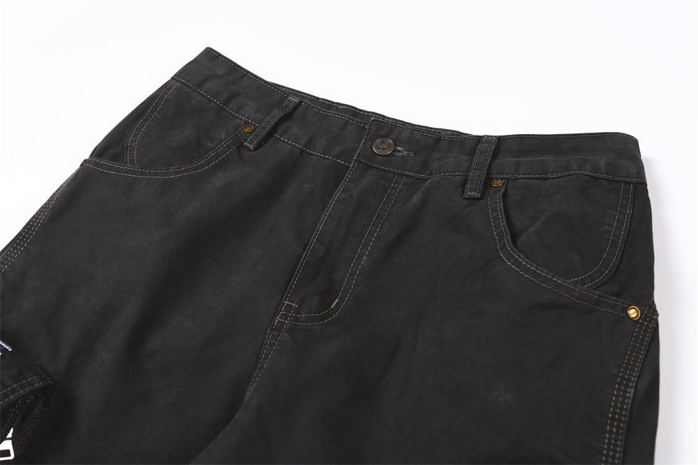 Close-up of black pants waistband with button closure, belt loops, and curved front pockets
