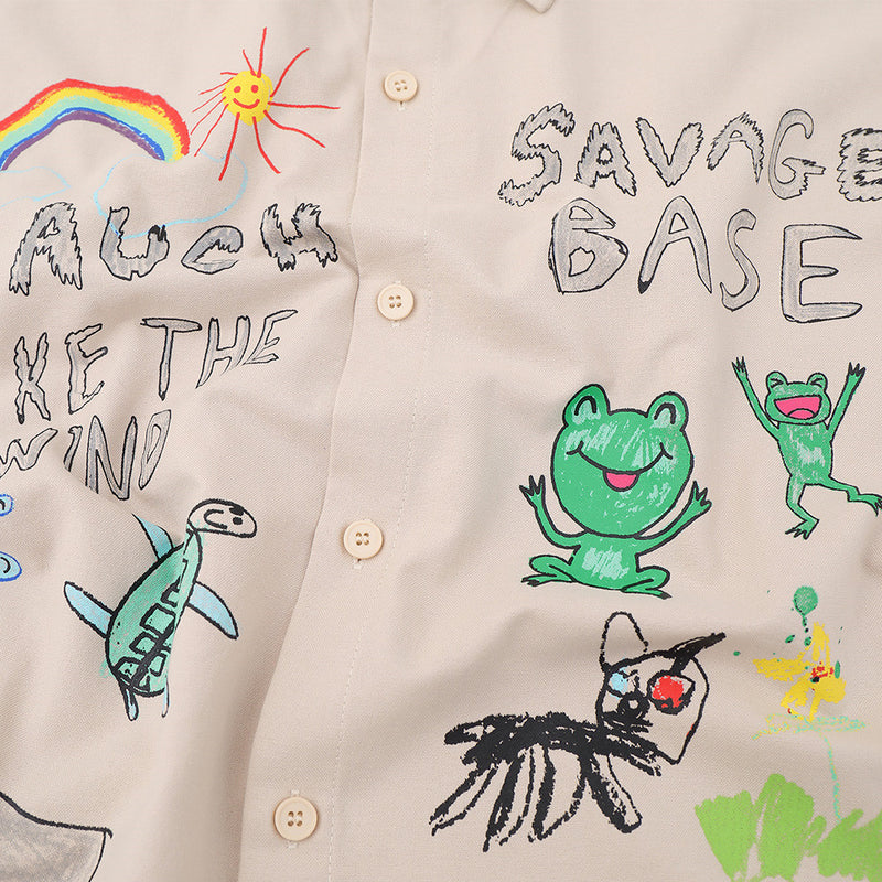 Close-up of shirt front graphic with rainbow, sun, frog, and dinosaur illustrations