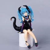 The Hatsune Miku Little Demon Sitting Pose 11cm PVC Figure captures an anime-style character with bright blue twin-tails, a black dress with purple accents, horn-like head accessories, and a scorpion-like tail. It sits poised on a small white cylinder, reminiscent of classic Hatsune Miku figures.