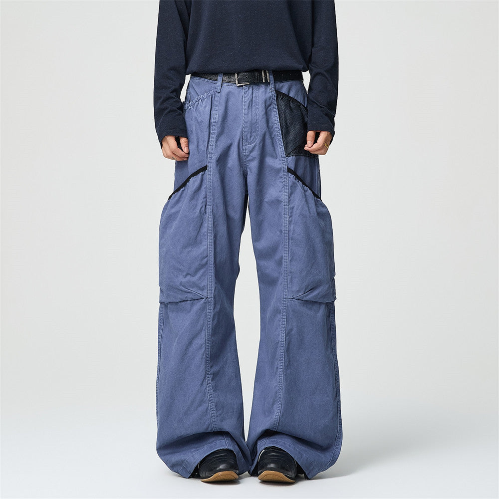 Men's wide-leg washed cargo pants in French blue with oversized side pockets and mesh paneling, streetwear styling