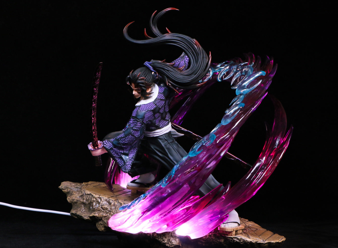 The Kokushibo Demon Slayer Figure is a 30cm PVC statue featuring dynamic sword-wielding posture on a rocky base, long black hair, and swirling pink and blue glowing effects, embodying the essence of a warrior in anime collectibles from the brand Demon Slayer.