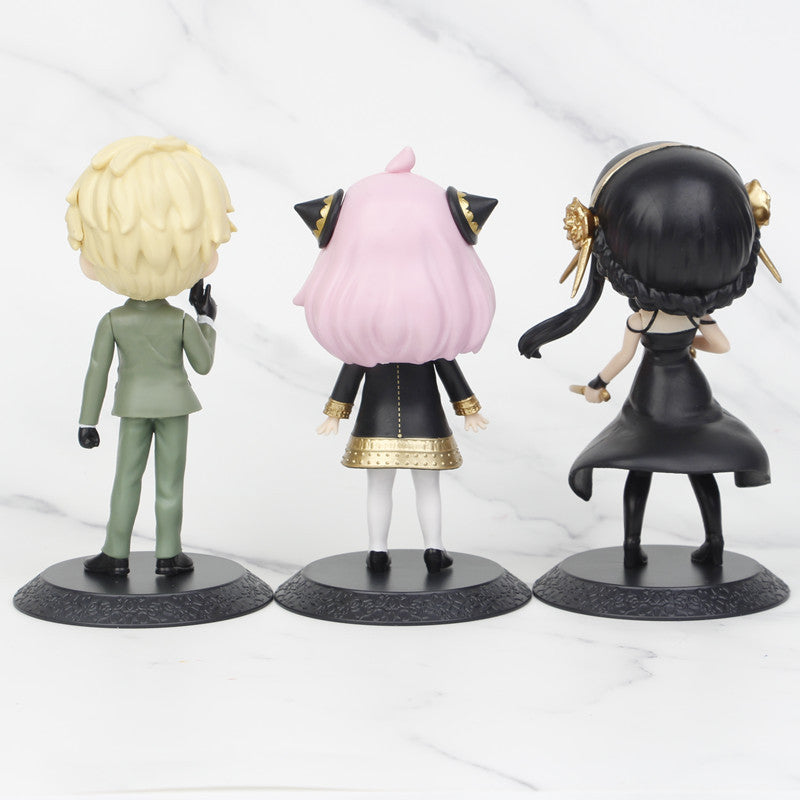 The Seakoff Spy x Family Complete Set features three 15cm chibi-style PVC figures—Anya, Loid, and Yor—each with unique hairstyles: blonde, pink, and long black. They wear green suits, black and gold outfits, and elegant black dresses on a white marble surface.