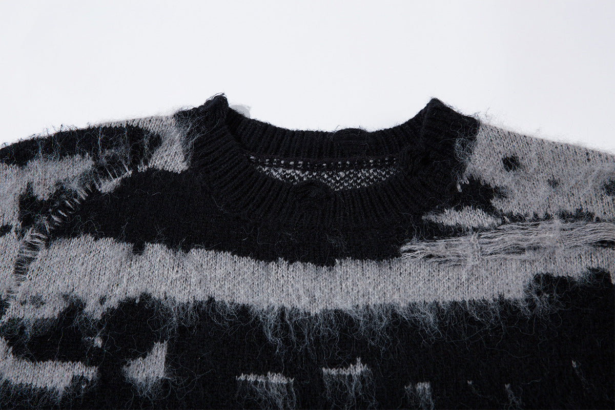 Close-up of the black ribbed crew neckline and distressed striped jacquard knit texture