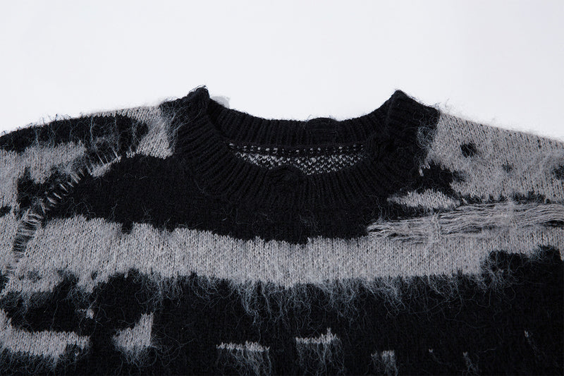 Close-up of the black ribbed crew neckline and distressed striped jacquard knit texture