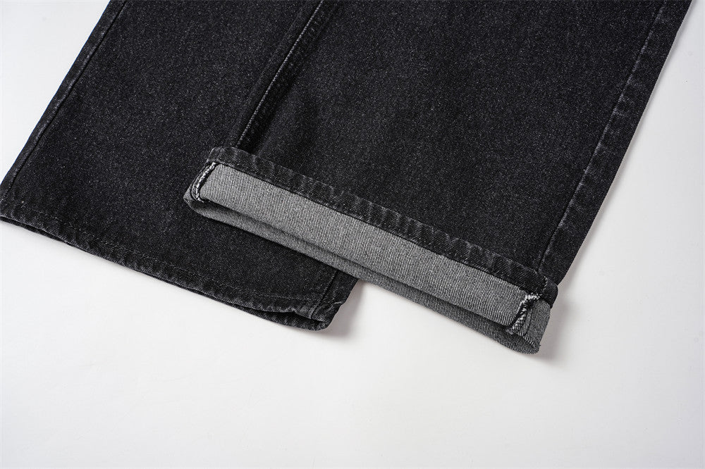 Cuffed hem detail on black denim jeans with gray inner cuff