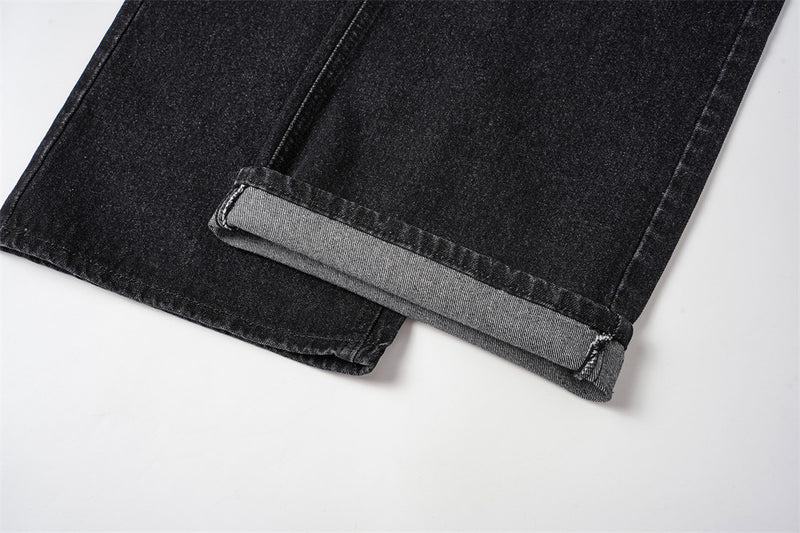 Cuffed hem detail on black denim jeans with gray inner cuff