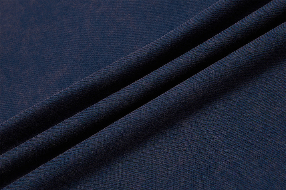 Close-up of navy blue colorblock T-shirt fabric with smooth folded texture and vintage raglan style look