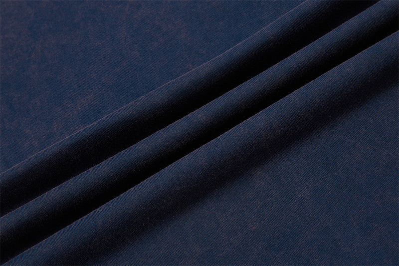 Close-up of navy blue colorblock T-shirt fabric with smooth folded texture and vintage raglan style look