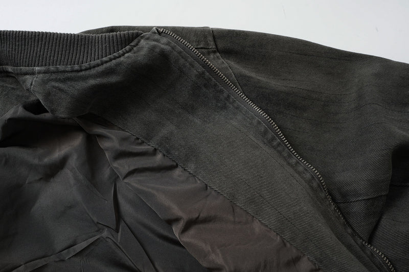 Veste bomber en jean délavé déconstruite à empiècement croisé et coutures effilochées