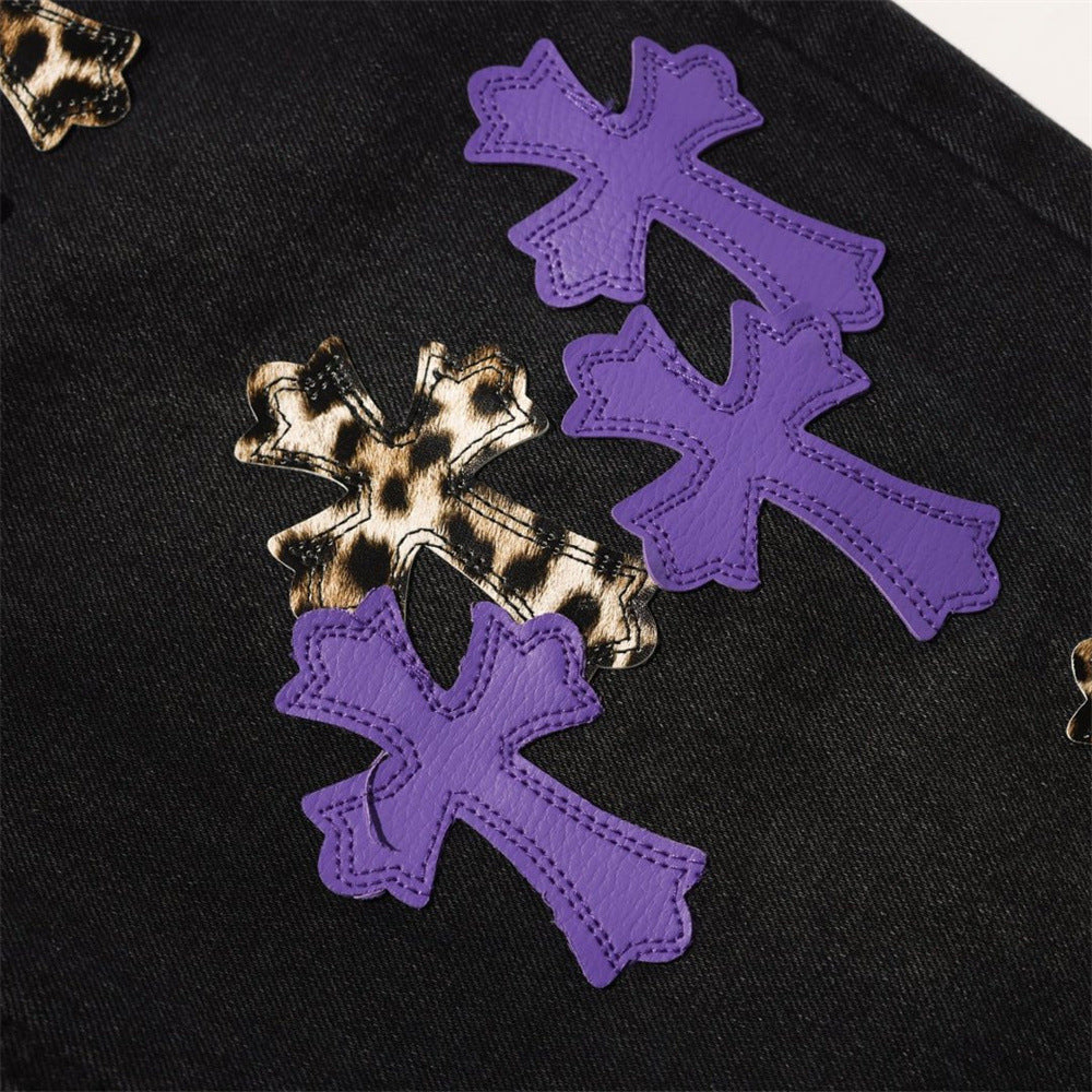 Close-up of purple and leopard cross patches on black denim