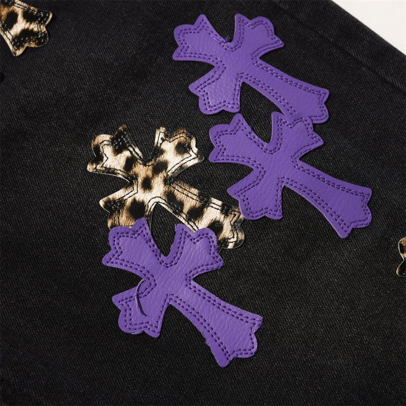 Close-up of purple and leopard cross patches on black denim