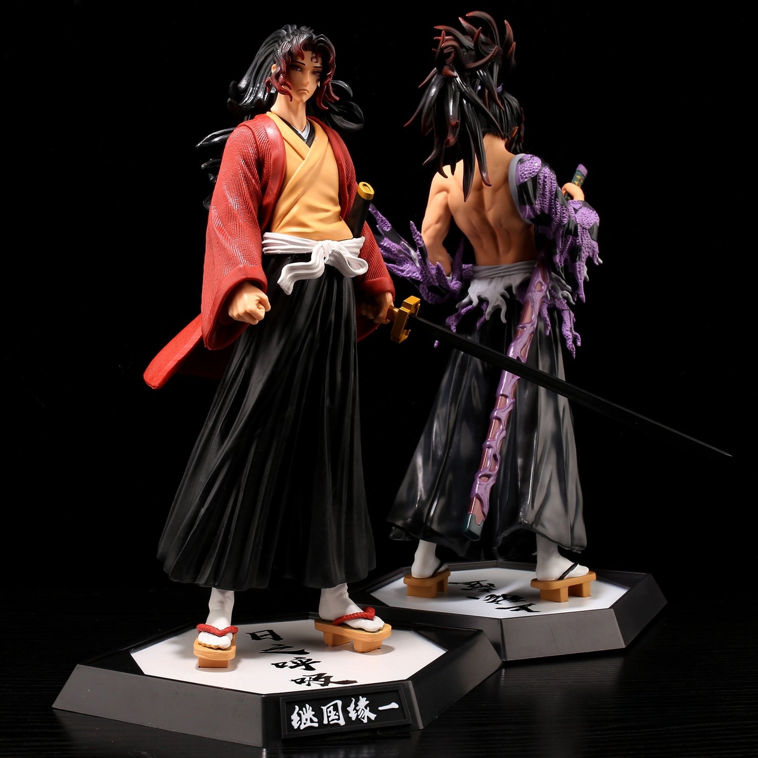 Displayed back-to-back on individual stands, the Demon Slayer figures include a Shinjuro Rengoku in a red robe with black hakama and sword, and another figure with spiky hair in purple cloth, each 29CM PVC action figures perfect for any Kimetsu no Yaiba fan collection.