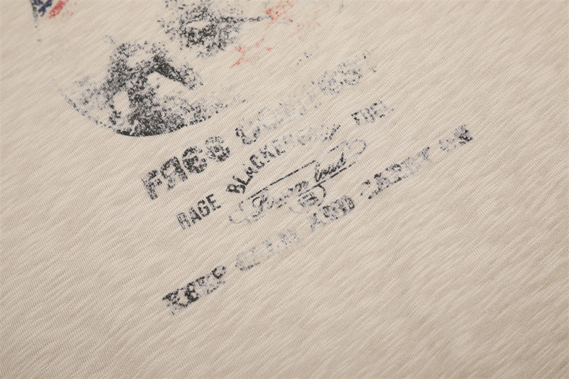 Close-up of printed text on beige tee front graphic near the lower chest