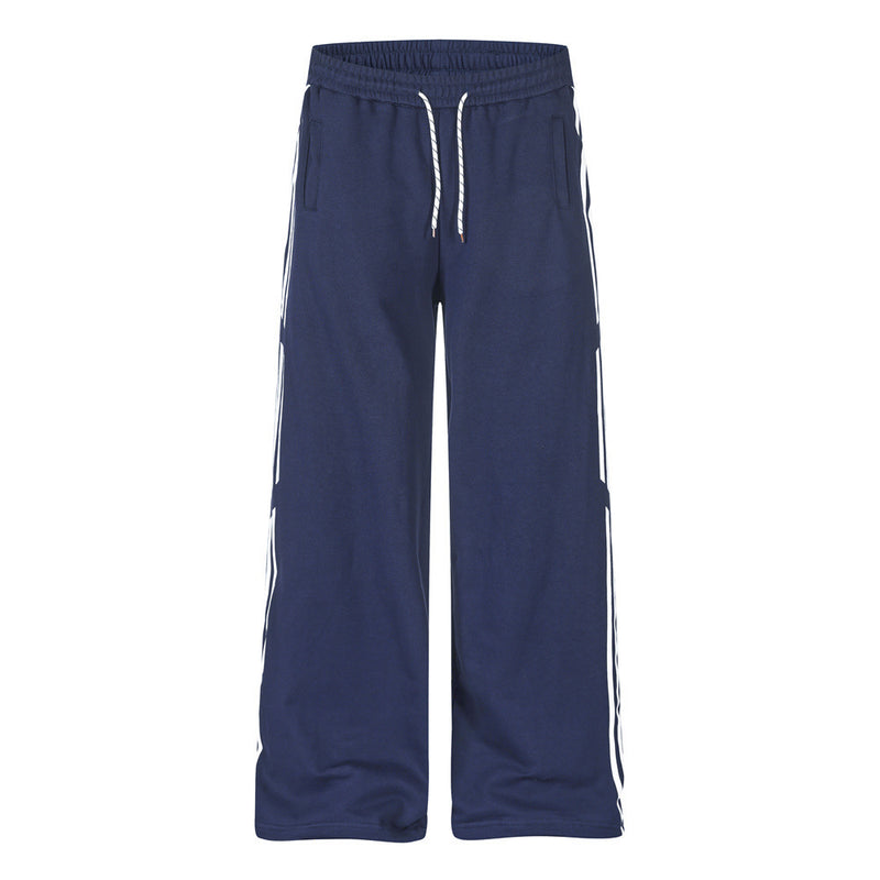 Men's navy blue wide-leg track pants with white contrast side stripes and rope drawstring waist, front and back view
