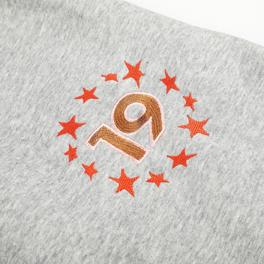 Close-up of star 19 embroidery on heather gray sweatpants