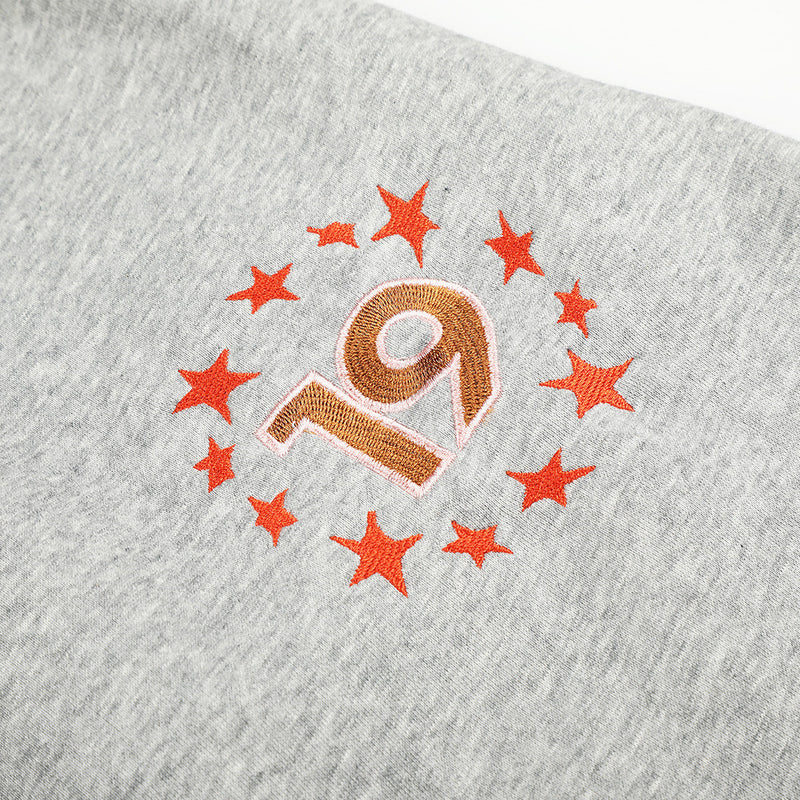 Close-up of star 19 embroidery on heather gray sweatpants