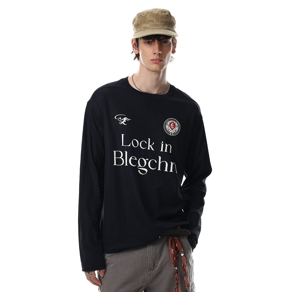 Black long sleeve crew neck tee worn by a model, front view with relaxed fit and chest print