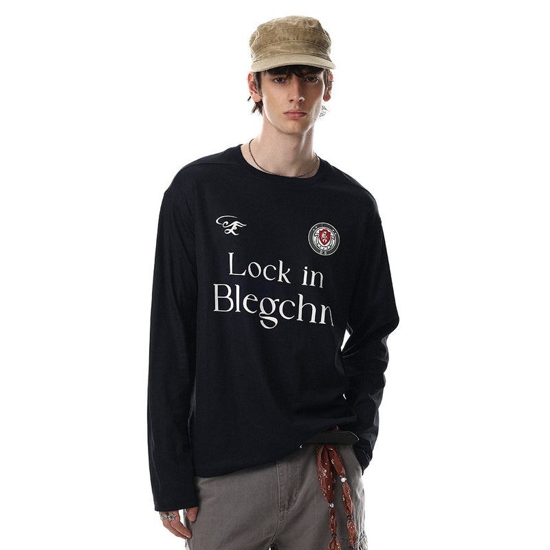 Black long sleeve crew neck tee worn by a model, front view with relaxed fit and chest print