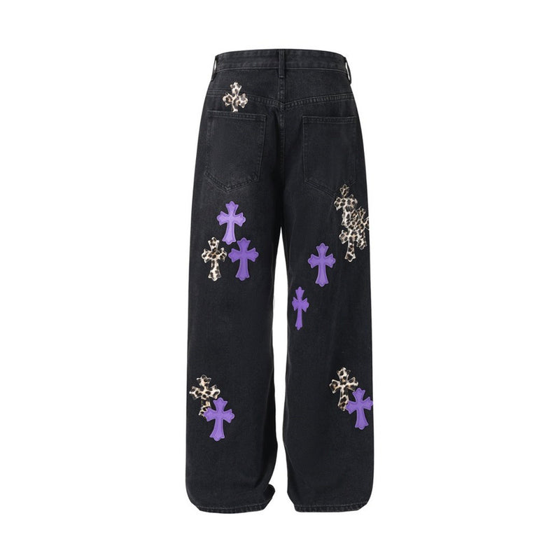 Black baggy jeans with purple and leopard cross patches, back flat lay