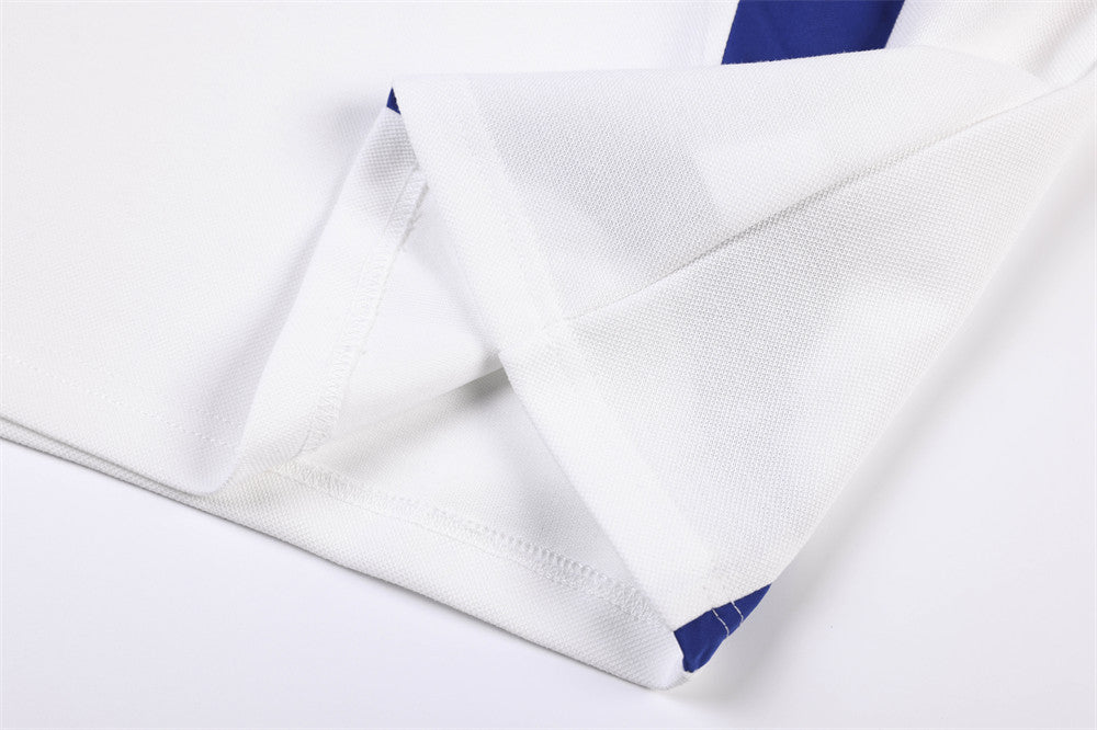 Close-up of white jersey hem and side seam with blue panel detail