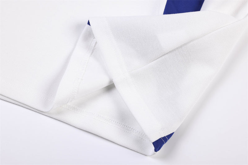 Close-up of white jersey hem and side seam with blue panel detail