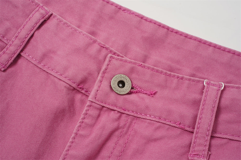 Zoomed-in front waistband detail with button and belt loop on rose pink shorts