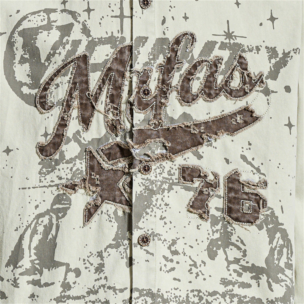 Close-up of front graphic on cream shirt with distressed brown appliqué lettering