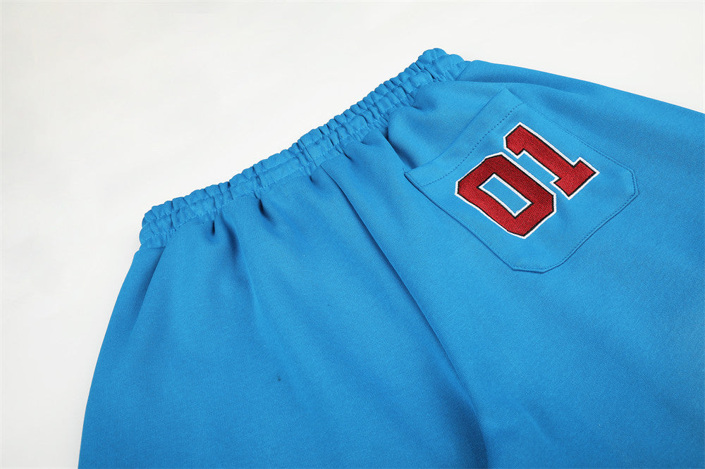 Close-up of blue sweatpants back pocket with 01 patch