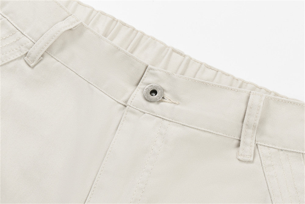 Close-up of cream pants waistband with button and belt loops