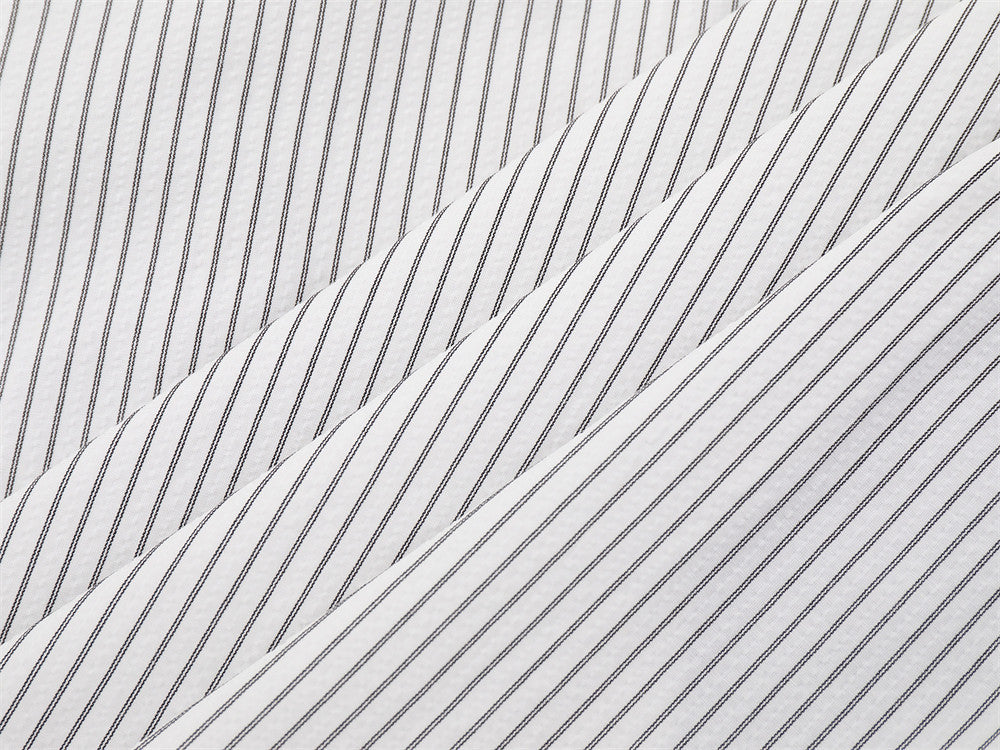 Close-up of white striped shirt fabric laid in overlapping folds
