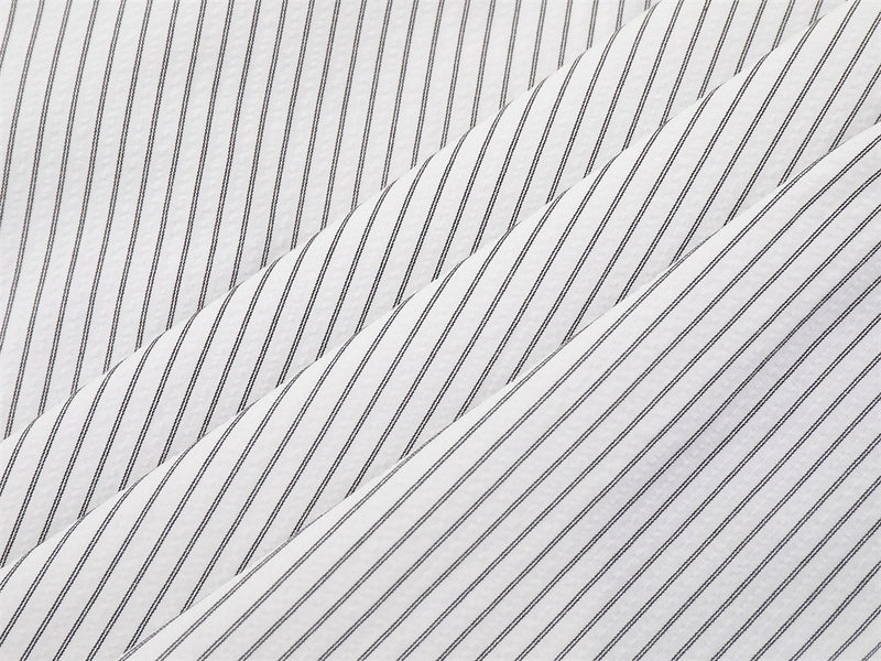 Close-up of white striped shirt fabric laid in overlapping folds