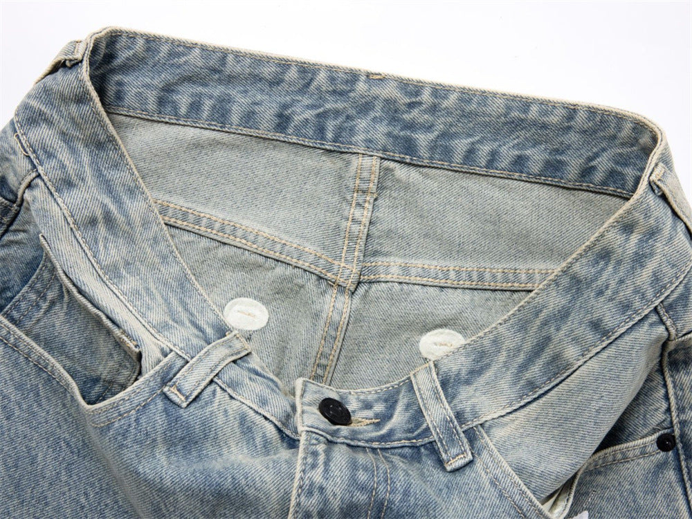 Close-up of denim waistband and button closure on light wash jeans