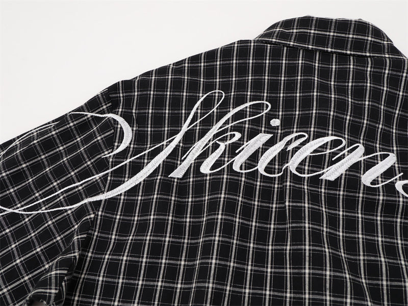 Black plaid shirt back view with white Gothic script across upper back