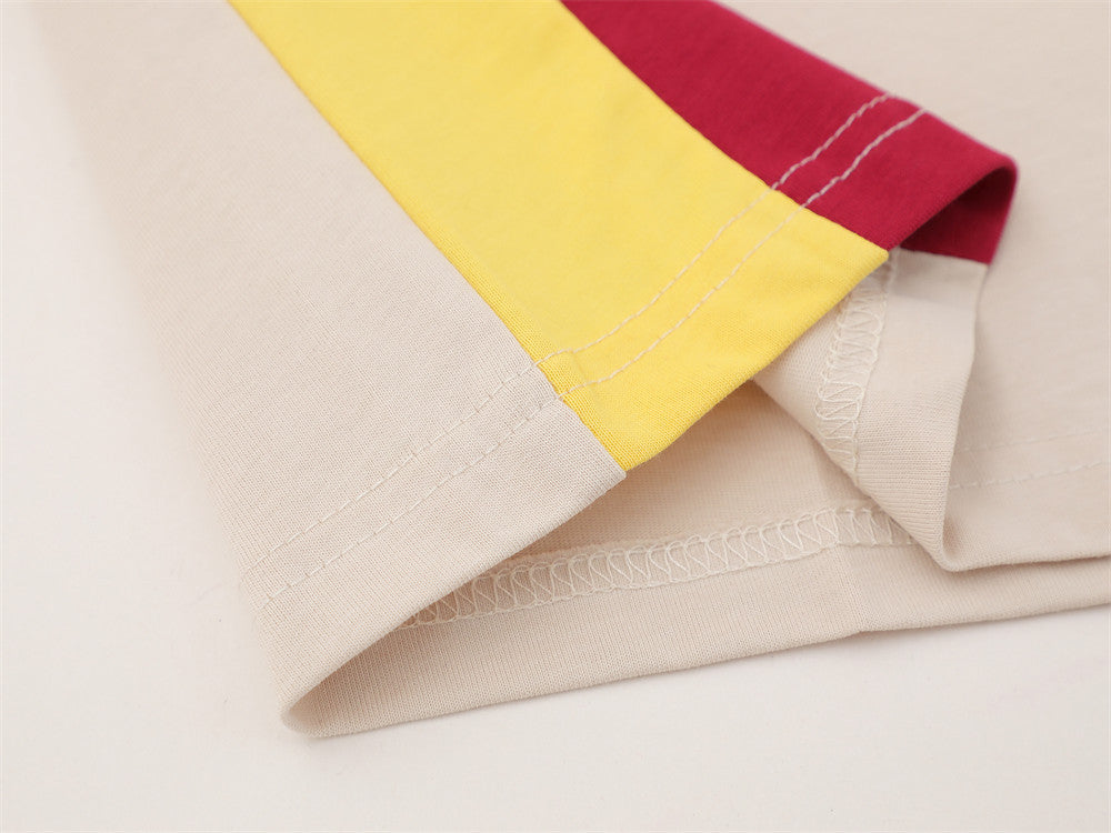 Close-up of yellow and red sleeve hem over cream fabric with visible stitching