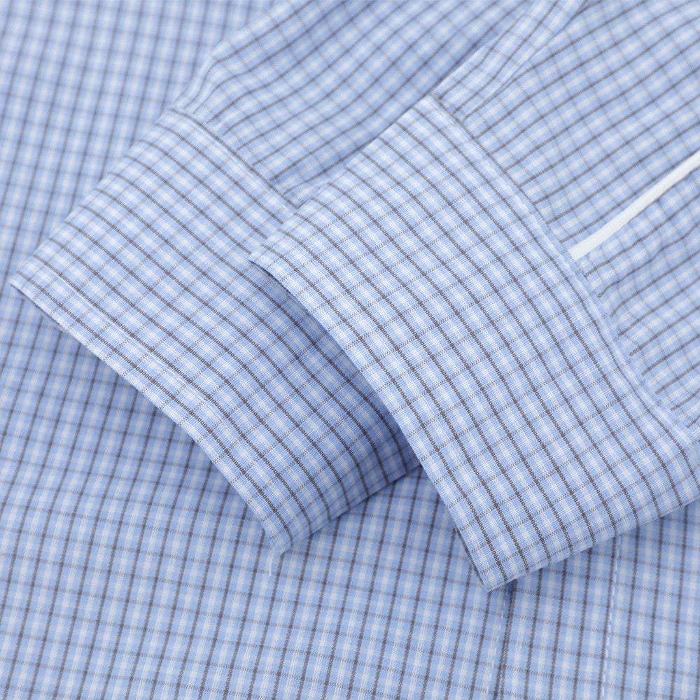 Close-up of light blue plaid shirt sleeve cuff with buttoned wrist detail