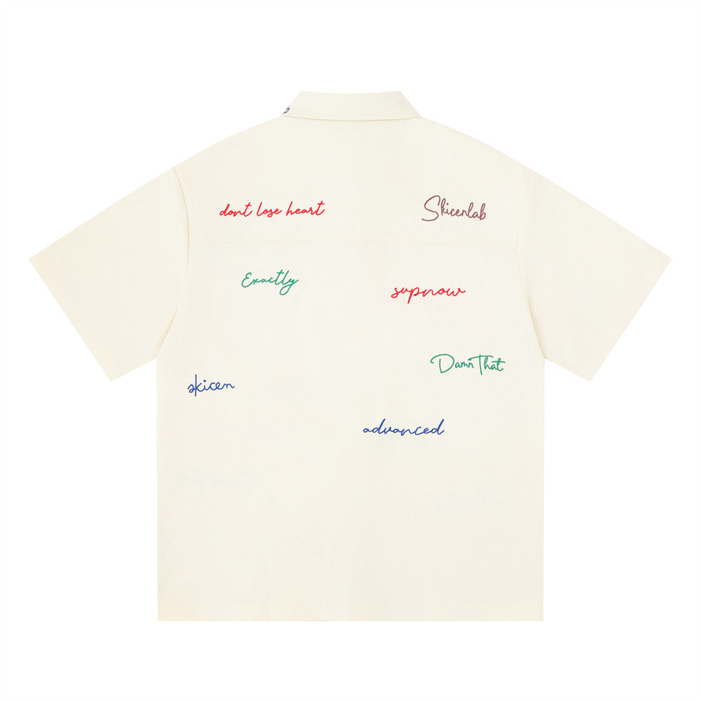 Cream short sleeve button-down shirt with multicolor graffiti script embroidery, back view