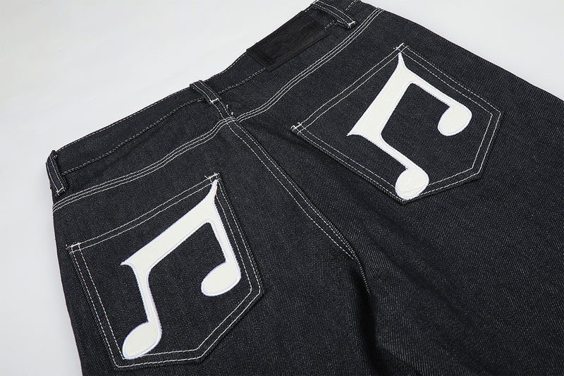 Jean baggy à jambes larges avec broderies et patch en cuir motif notes de musique — Denim noir brut