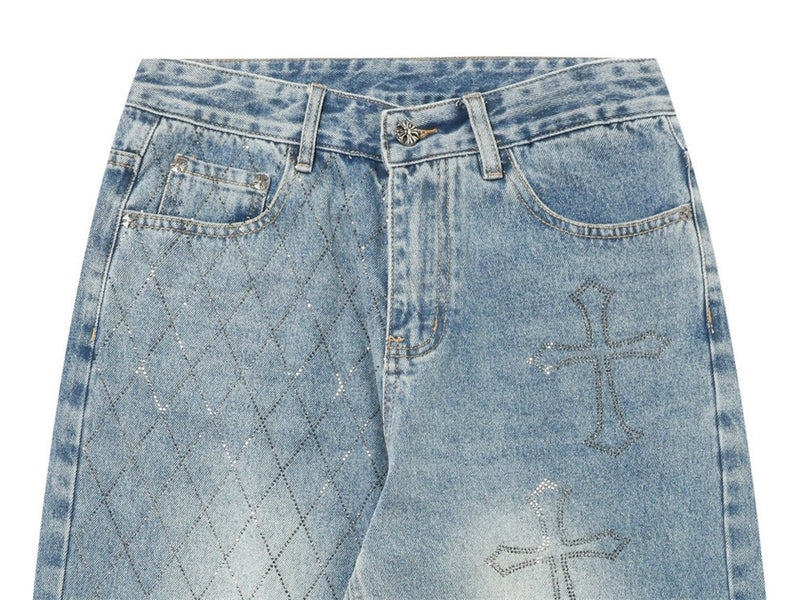 Upper front of light blue jeans with argyle panel, cross graphics, belt loops and button waist