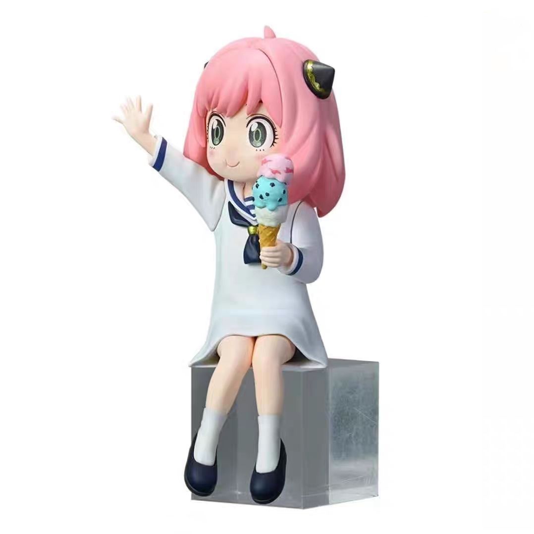 The Anya Forger with Ice Cream Figure from Spy × Family features pink hair, cat ear headbands, and perches on a clear block. Dressed in white with blue trim, this PVC anime collectible waves one hand while holding a colorful ice cream cone—a charming piece for any fan.