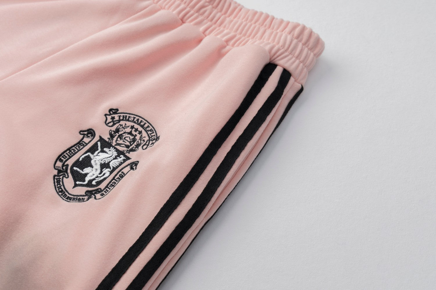 Pantalon de survêtement wide leg – Rose délavé avec bande latérale et écusson brodé