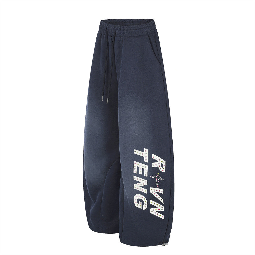 Navy wide leg sweatpants with rhinestone letter print on the leg, angled front view