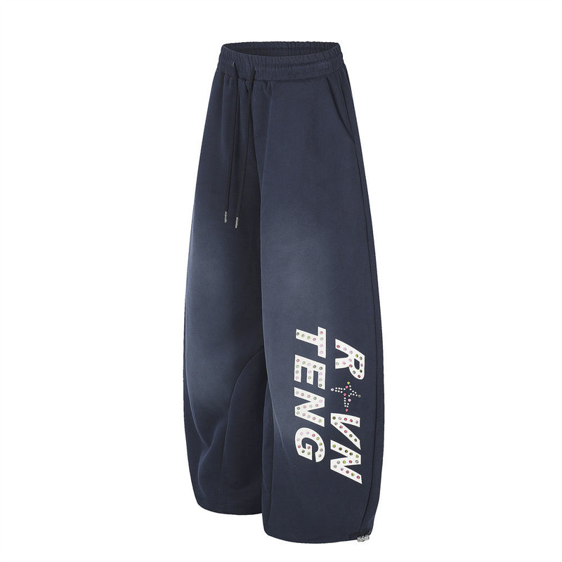 Navy wide leg sweatpants with rhinestone letter print on the leg, angled front view
