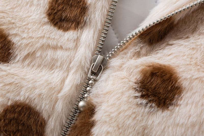 Close-up of the metal zipper and pull on cream faux shearling fabric with brown polka dots