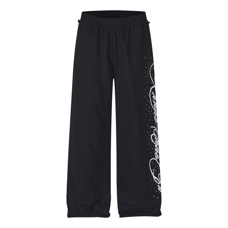Men's black wide-leg sweatpants with rhinestone script graphic detail on the leg